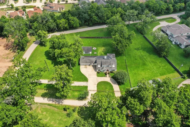 an aerial view of a house with a yard and lake view