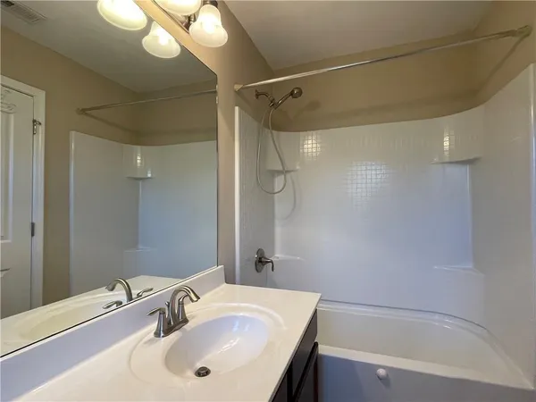 a bathroom with a sink mirror and a bathtub