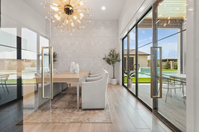 a dining room with glass top table and chairs