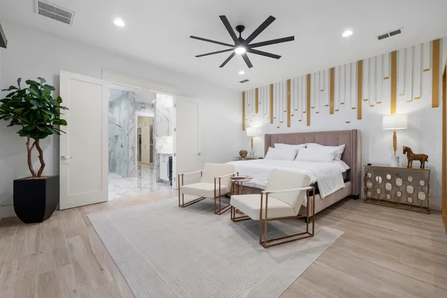 a bedroom with a large bed and a chandelier