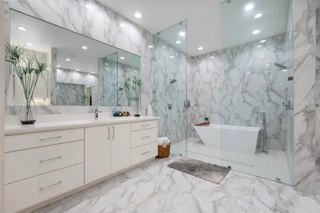 a bathroom with a double vanity sink a toilet a mirror and shower