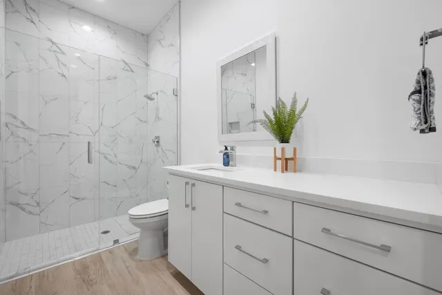 a bathroom with a sink a toilet and shower