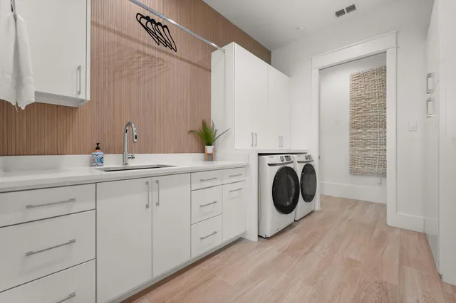 a utility room with sink dryer and washer