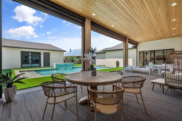a dinning table and chairs in the patio of a house