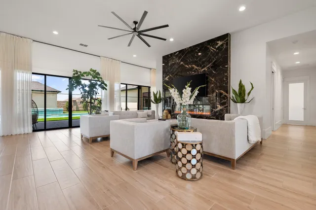 a living room with furniture a chandelier and a large window
