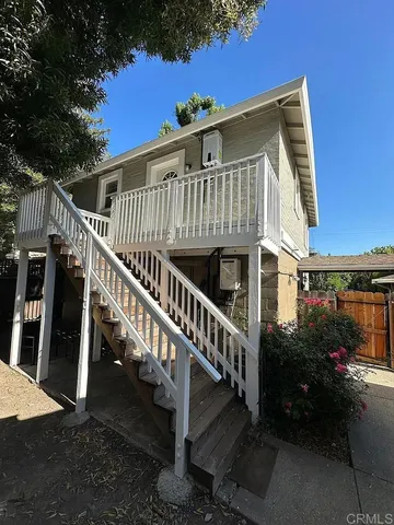 a view of a house with backyard and deck