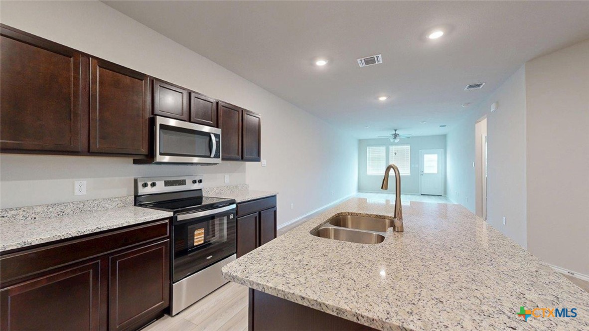1111 Stone Vly Road Temple, TX 76502 - Photo 5 of 21 a kitchen with granite countertop a sink and stainless steel appliances