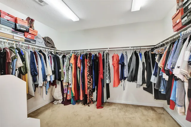 a view of walk in closet with clothes
