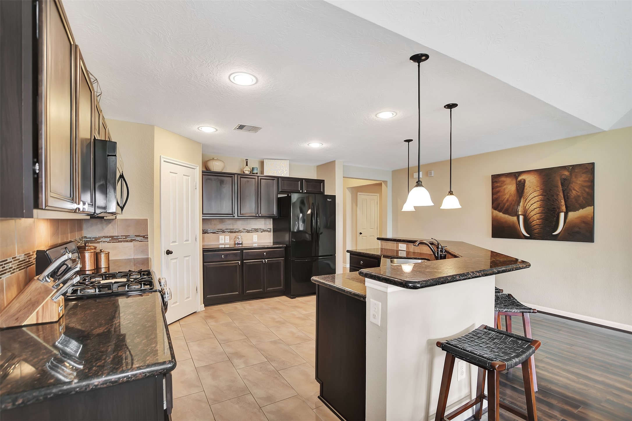 9706 Lockhart Reach Lane Humble, TX 77396 - Photo 7 of 25 a kitchen with a sink a stove a refrigerator and chairs
