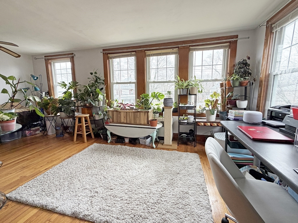 75-77 Dale Street, Unit 77 Waltham, MA 02451 - Photo 4 of 17 a living room filled with furniture gym equipment and a potted plant