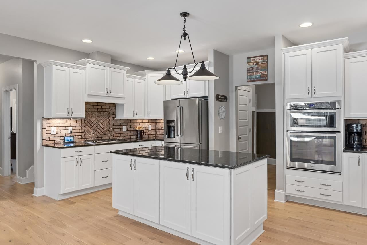 Custom chef's kitchen with brick backsplash and granite counters. Refrigerator conveys! Kitchen