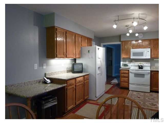 5407 Fortunes Ridge Drive Durham, NC 27713 - Photo 5 of 22 a kitchen with a sink a stove a refrigerator and cabinets
