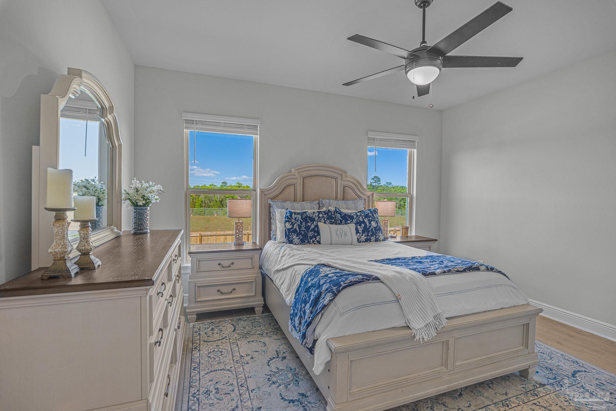 5380 Adeline Circle Pace, FL 32571 - Photo 16 of 35 a bedroom with a large bed and a chandelier