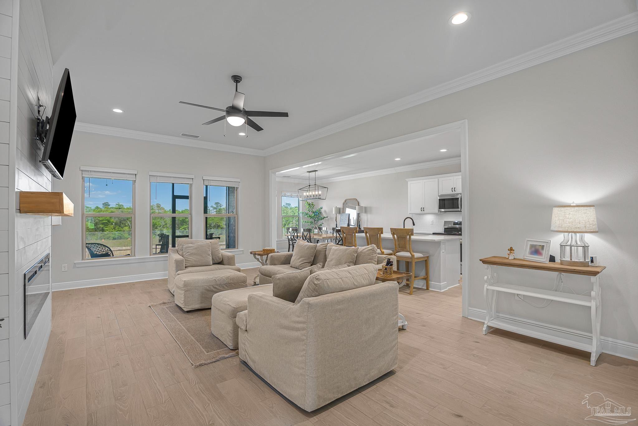 5380 Adeline Circle Pace, FL 32571 - Photo 5 of 35 a living room with furniture a flat screen tv and a large window