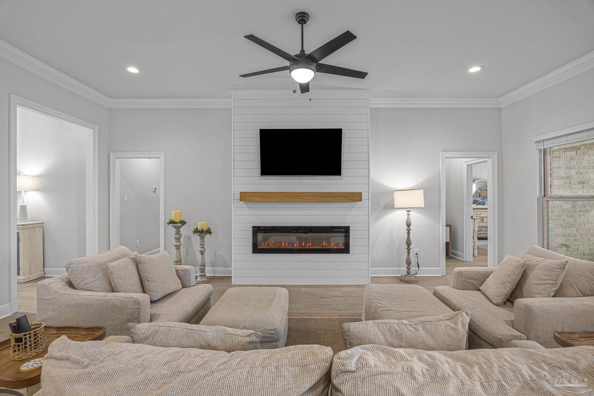 5380 Adeline Circle Pace, FL 32571 - Photo 6 of 35 a living room with furniture a fireplace and a flat screen tv