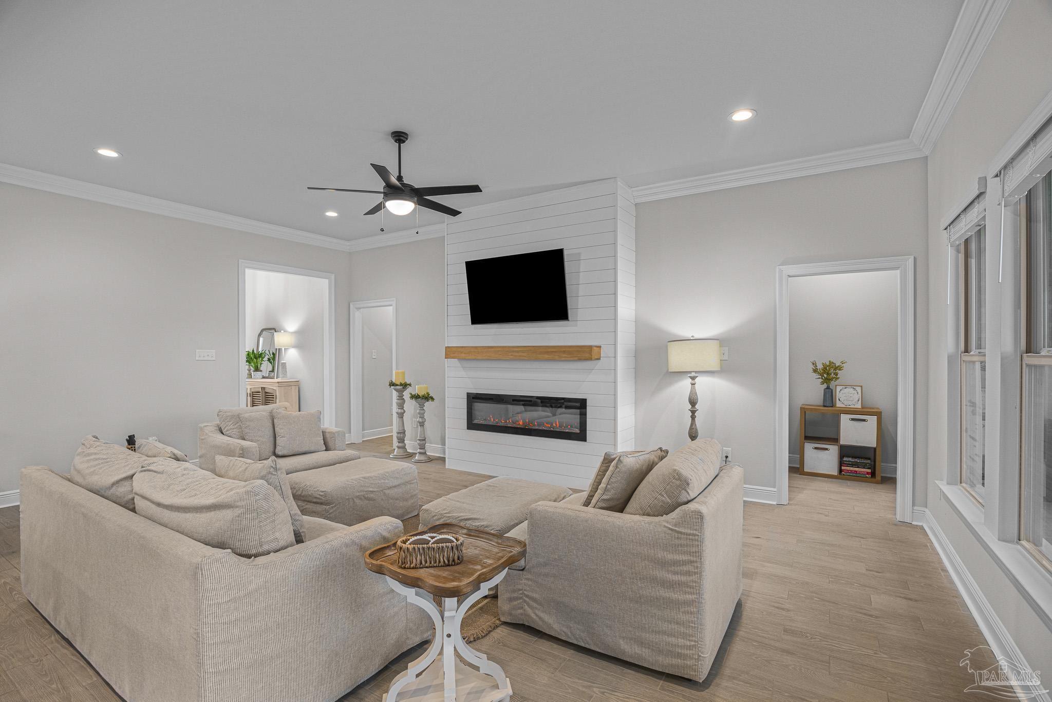 5380 Adeline Circle Pace, FL 32571 - Photo 7 of 35 a living room with furniture a fireplace and a flat screen tv