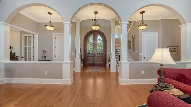 a kitchen with stainless steel appliances kitchen island granite countertop a stove a sink and white cabinets with wooden floor