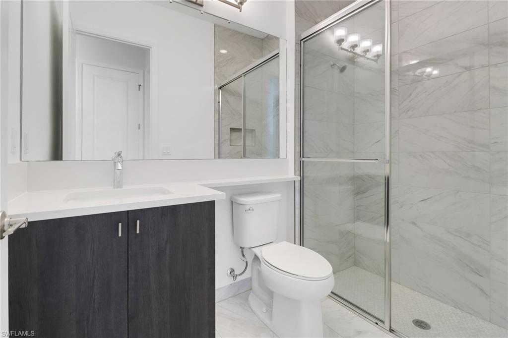 20458 Fair Oak Lane Estero, FL 33928 - Photo 14 of 40 Bathroom featuring vanity, an enclosed shower, and toilet