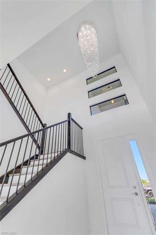 20458 Fair Oak Lane Estero, FL 33928 - Photo 15 of 40 Stairway featuring a chandelier