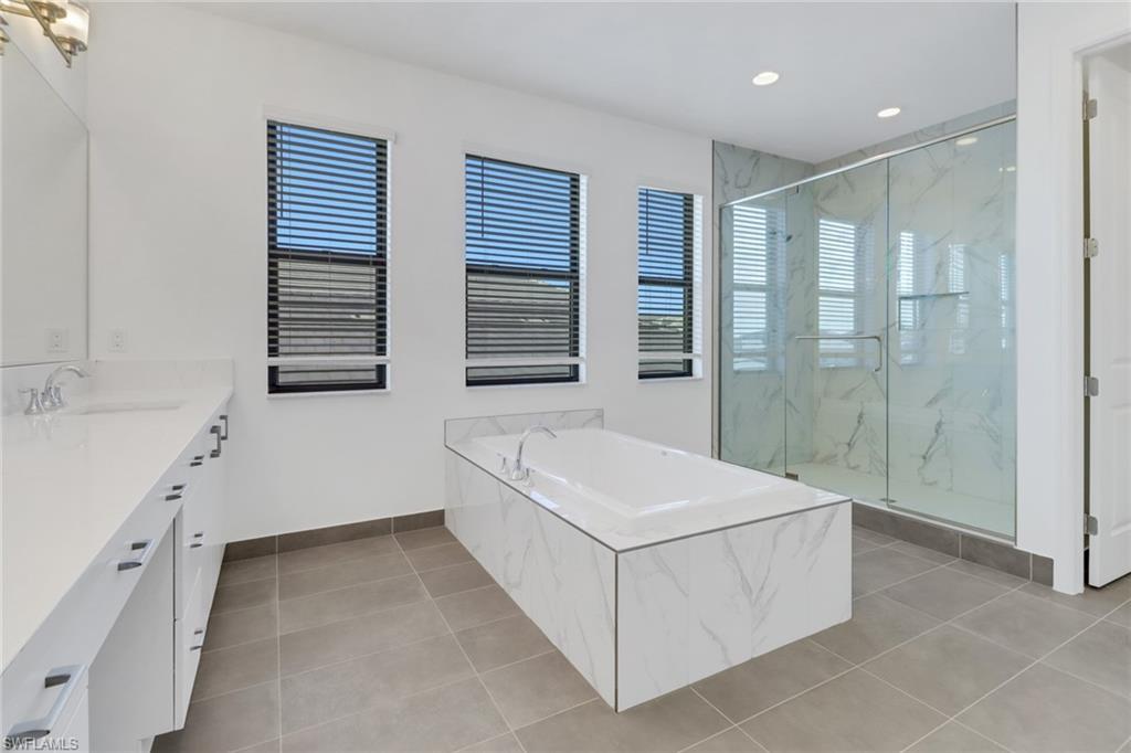 20458 Fair Oak Lane Estero, FL 33928 - Photo 21 of 40 Bathroom featuring tile patterned flooring, vanity, and independent shower and bath