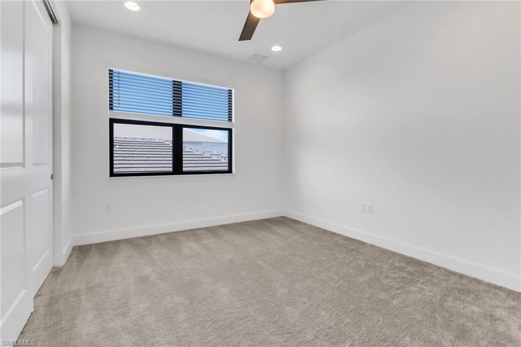 20458 Fair Oak Lane Estero, FL 33928 - Photo 22 of 40 Empty room with ceiling fan and light carpet