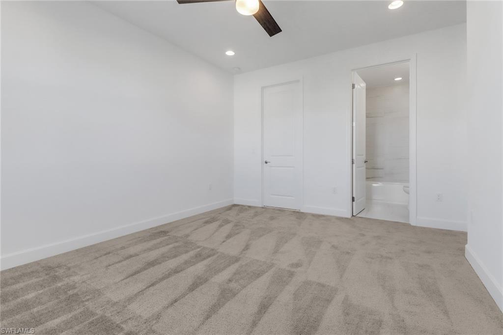 20458 Fair Oak Lane Estero, FL 33928 - Photo 29 of 40 Unfurnished bedroom featuring a closet, light colored carpet, ensuite bath, and ceiling fan