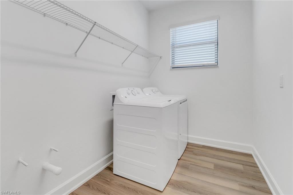 20458 Fair Oak Lane Estero, FL 33928 - Photo 31 of 40 Clothes washing area with wood-type flooring and washing machine and clothes dryer