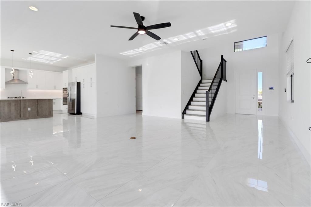 20458 Fair Oak Lane Estero, FL 33928 - Photo 4 of 40 Unfurnished living room featuring ceiling fan and sink