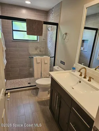 a bathroom with a sink a toilet and mirror