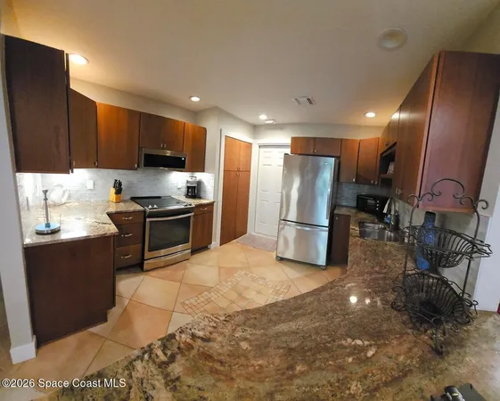 a kitchen with stainless steel appliances a refrigerator a sink a stove a microwave and cabinets