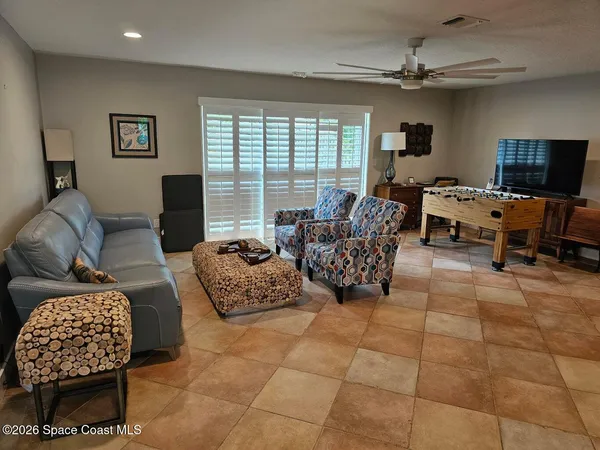 a living room with furniture floor to ceiling window and a flat screen tv