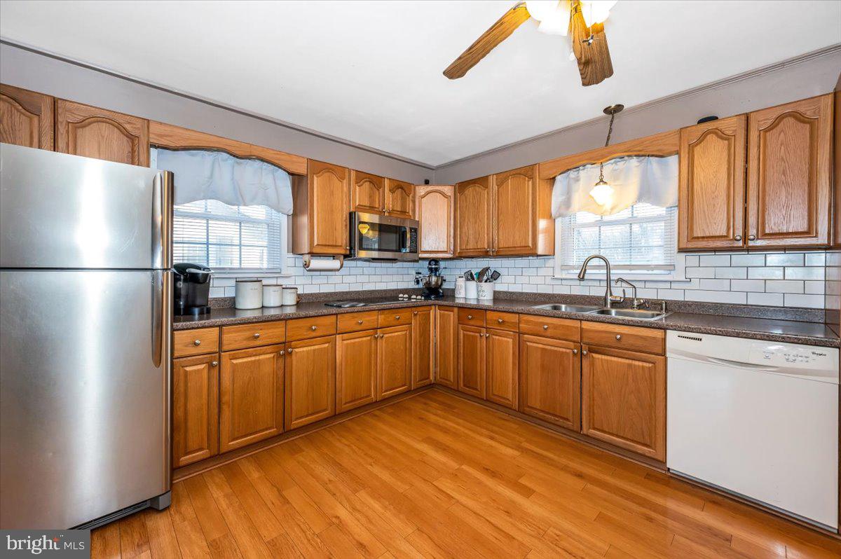 15225 Clear Spring Road Williamsport, MD 21795 - Photo 11 of 44 a kitchen with stainless steel appliances granite countertop a refrigerator a sink dishwasher a stove with wooden cabinets and floor