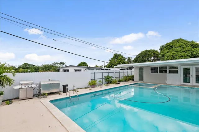 a view of a house with pool and chairs