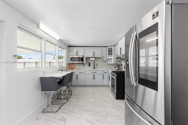 a kitchen with stainless steel appliances granite countertop a refrigerator and a stove top oven