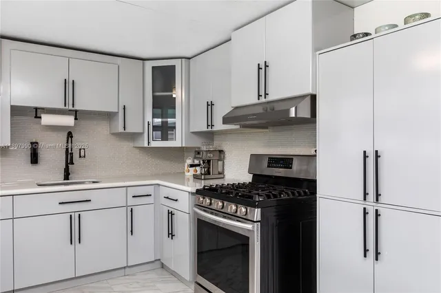 a kitchen with cabinets stainless steel appliances and a sink