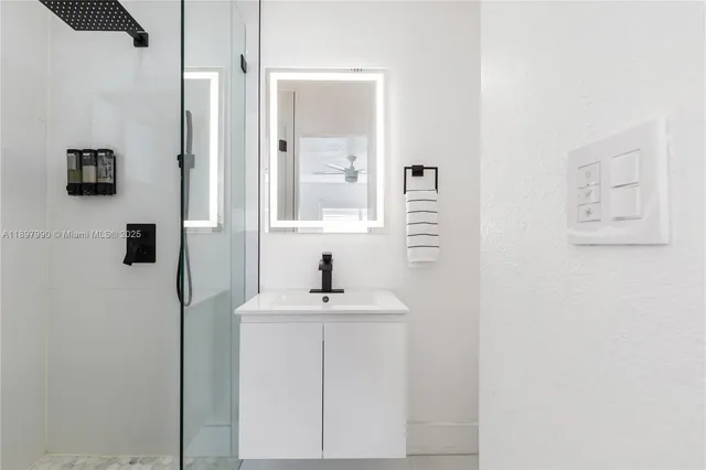 a bathroom with a sink a mirror and shower