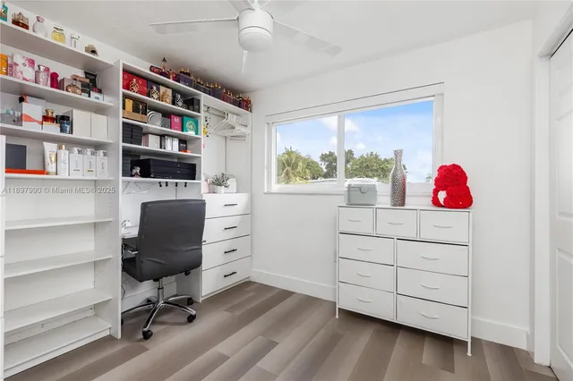 a view of a workspace with furniture and a bookshelf
