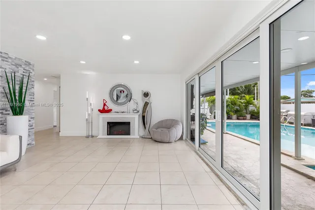 a living room with furniture a fireplace and a floor to ceiling window