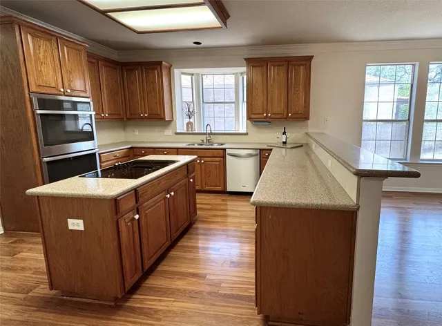 a kitchen with wooden cabinets a sink and appliances