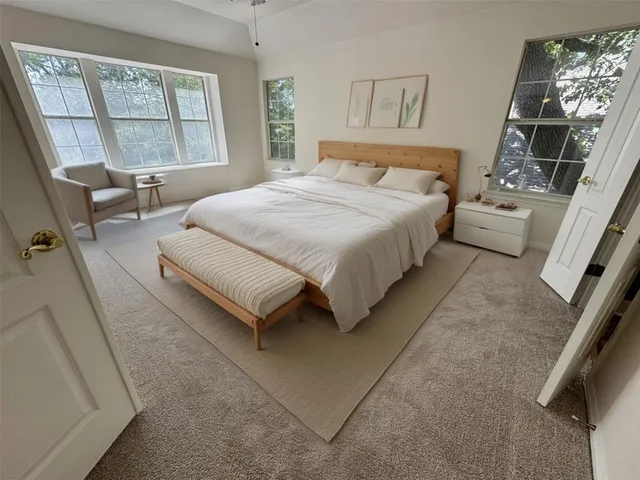 a spacious bedroom with a bed couch and a window