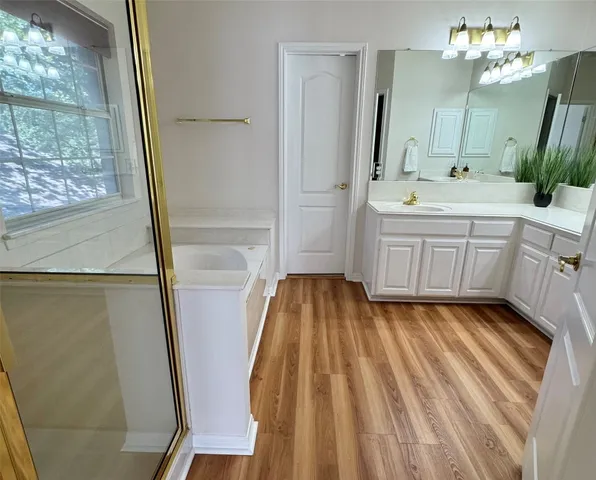 a bathroom with a double vanity sink a mirror a bathtub and shower