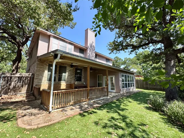 a view of a house with a yard and wooden fence