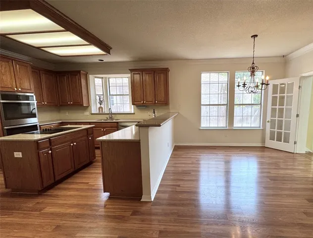 a kitchen with stainless steel appliances granite countertop wooden floors and sink