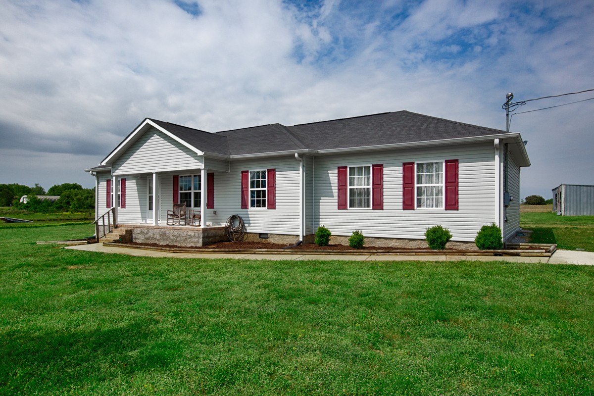 253 Old Baptist Road Ardmore, TN 38449 - Photo 2 of 23 a front view of a house with a yard and porch