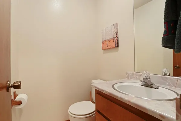 a bathroom with a granite countertop sink toilet and mirror