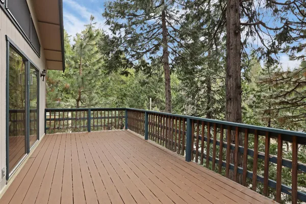 a balcony with wooden floor and trees