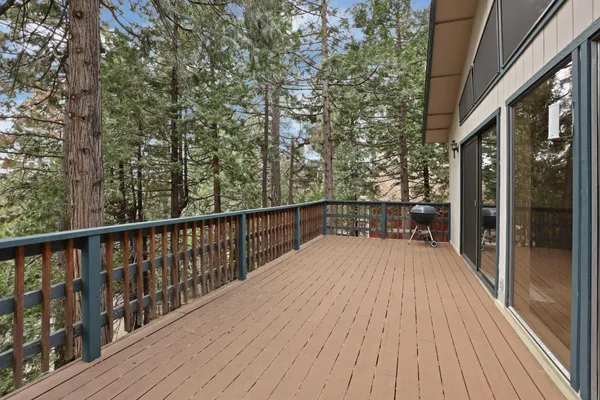 a balcony with wooden floor and yard in the back
