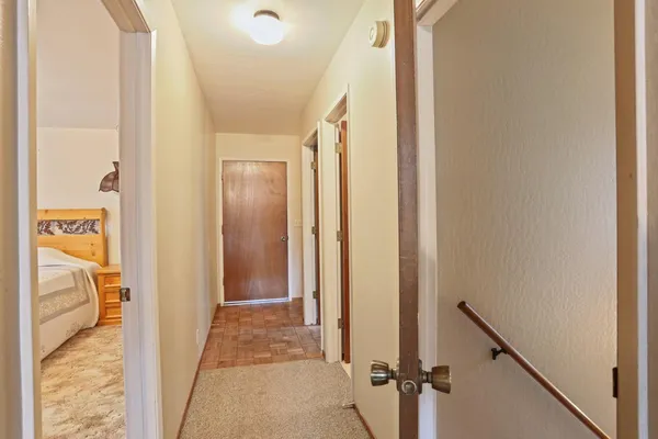 a view of a hallway with wooden floor and staircase