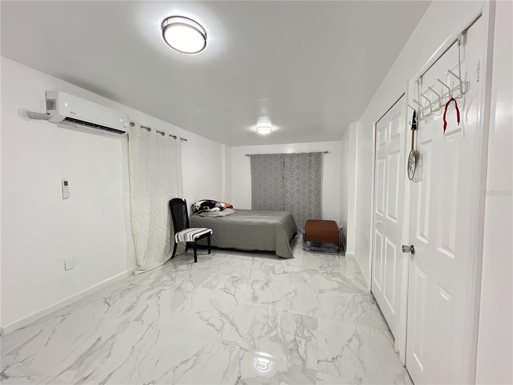 902 San Domingo Road Orlando, FL 32808 - Photo 13 of 18 a bed room with a bed and a chair