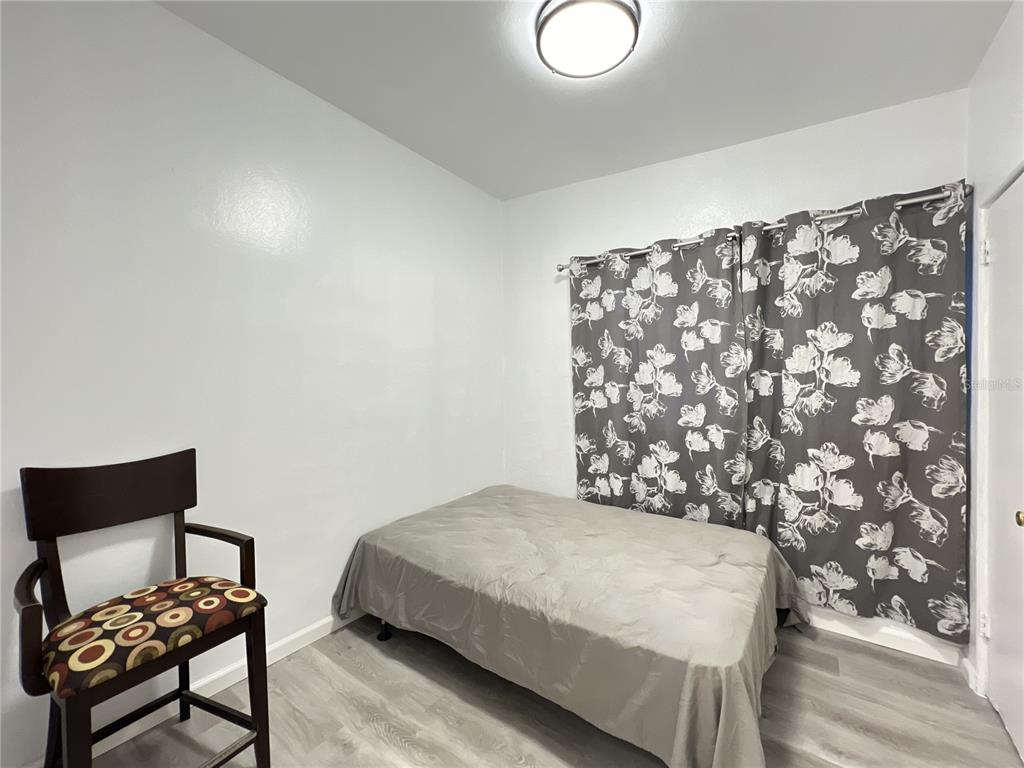 902 San Domingo Road Orlando, FL 32808 - Photo 15 of 18 a bedroom with a bed and a chair